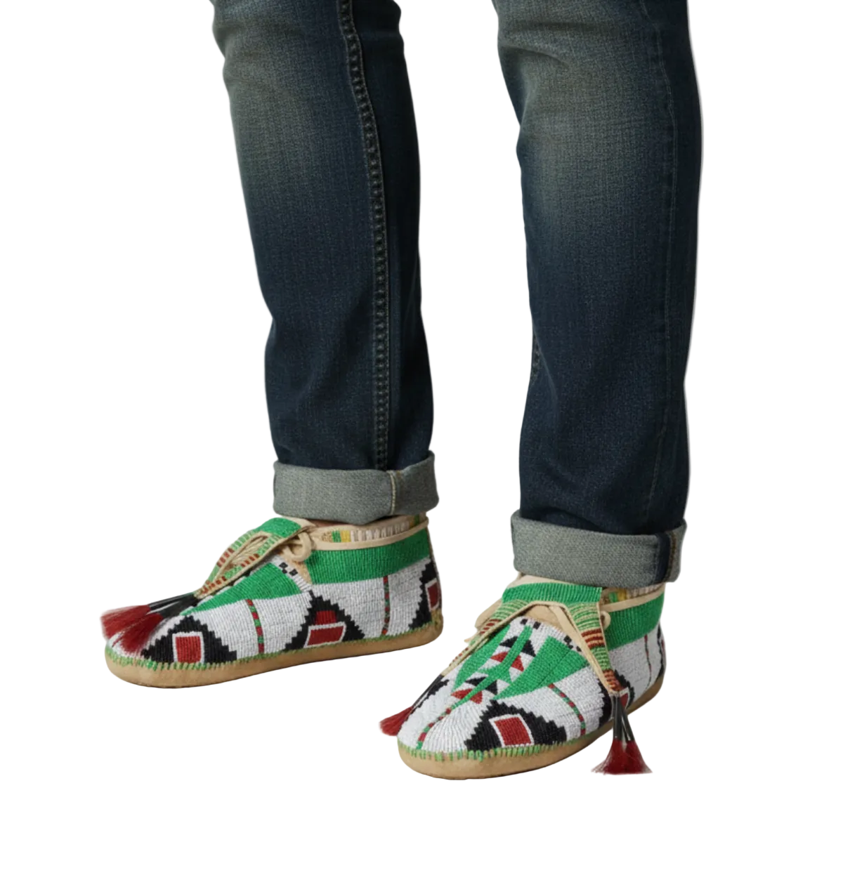 Pair of handcrafted moccasins with intricate patterns on a wooden floor.